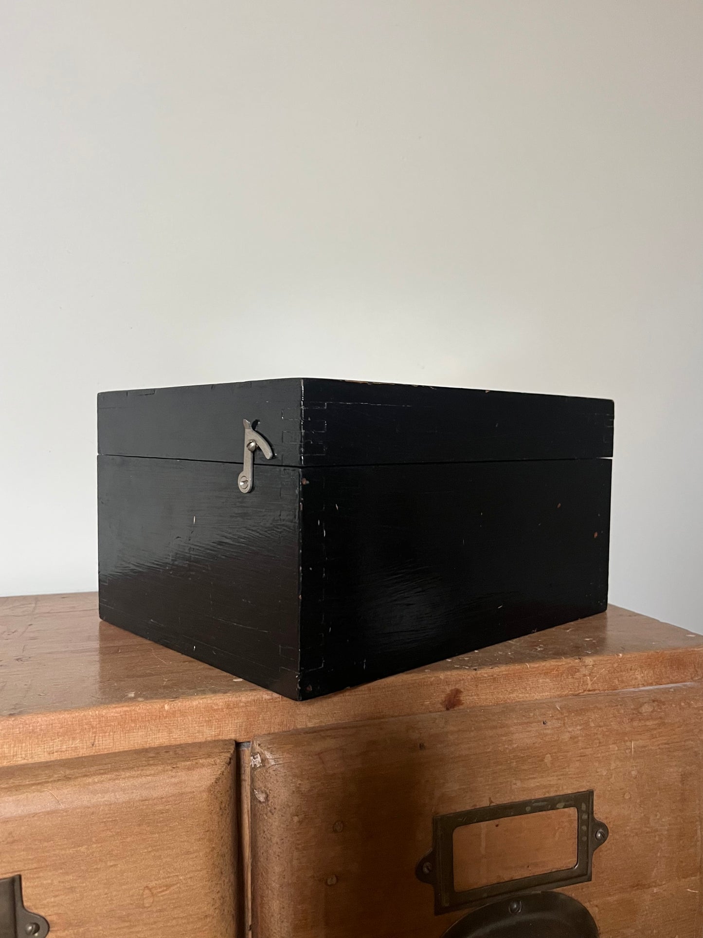 Black wooden box on a wooden surface with a plain background